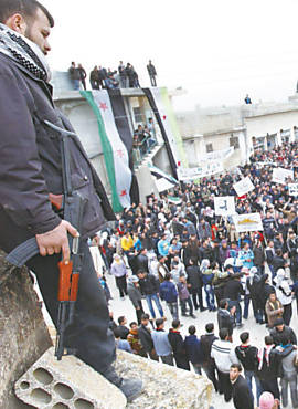 Armado, opositor de Assad assiste a protesto em Idlib (Sria)