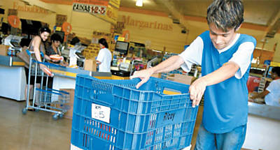 Funcionrio de supermercado carrega compras para entrega na casa de cliente em lojas da rede em Ribeiro Preto