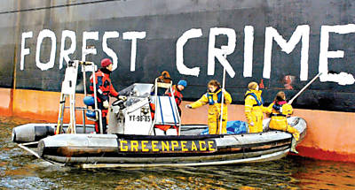 Ativistas do Greenpeace pintam inscrição com os dizeres "crime florestal" em navio com soja produzida na Amazônia