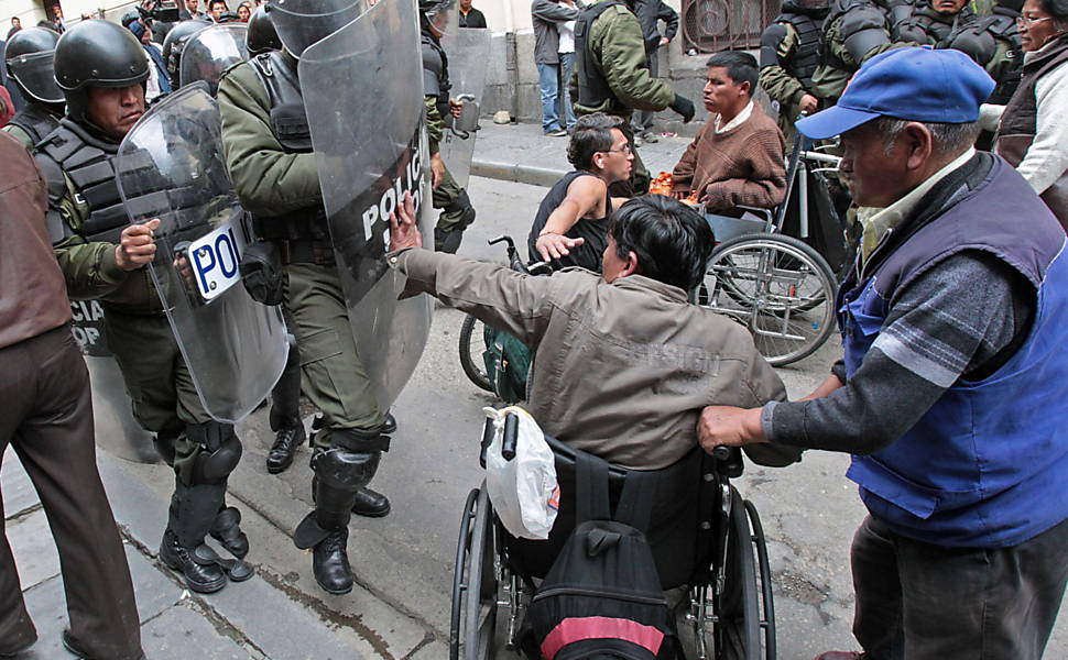 Policiais bolivianos entram em confronto com deficientes durante manifestação em frente ao palácio presidencial, em La Paz