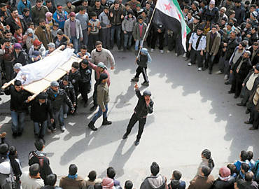 Opositores sírios, com bandeira do país pré-Assad, acompanham funeral de uma vítima da violência na cidade de Idlib