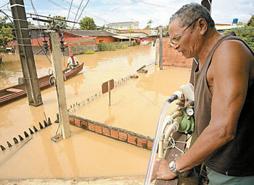 O aposentado Pedro Augusto da Silva, 84, pai de Marina Silva, observa de sua casa a cheia do rio Acre, em Rio Branco