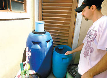 O msico Ronaldo Garcia, 39, mostra tambores que usa para armazenar gua; escassez  recorrente na Lagoinha, diz ele