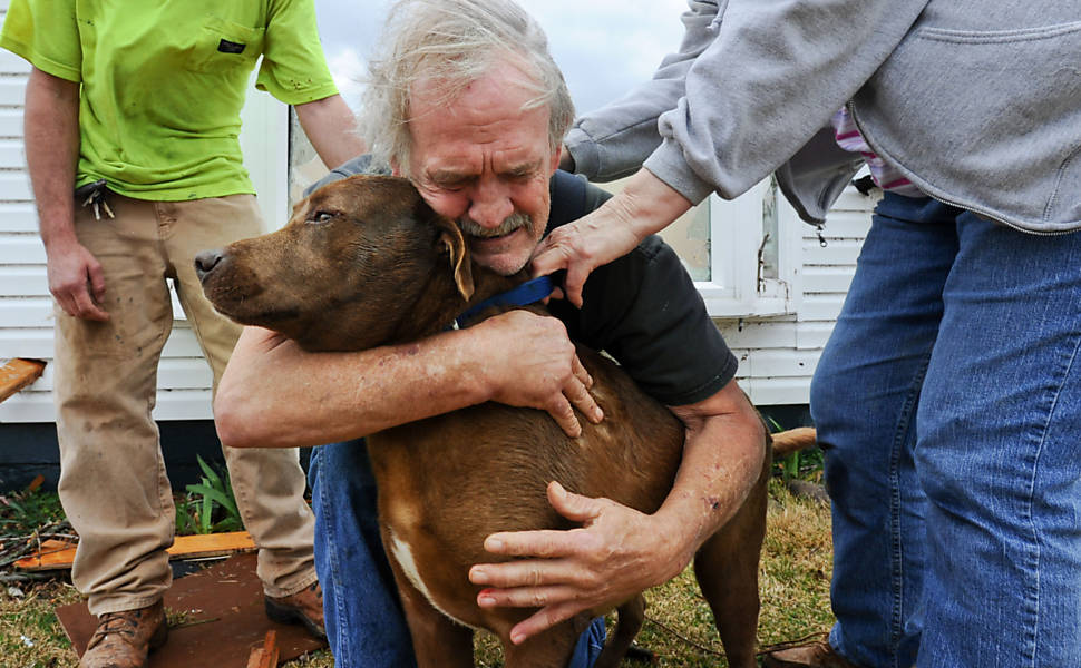 Homem abraça seu cachorro depois de encontrá-lo no meio dos destroços em Harveyville, no Kansas Leia mais
