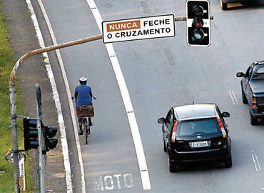 Na guerra por espao no trnsito paulistano, ciclista trafega em faixa exclusiva para motocicletas na avenida Sumar