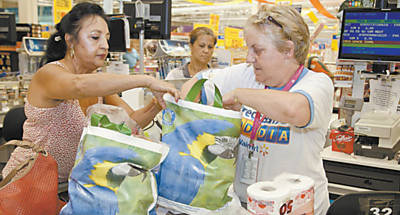 Cliente do Walmart recebe sacola reutilizvel no Dia do Consumidor; ao era parte de acordo entre associao de supermercados, Promotoria e Procon