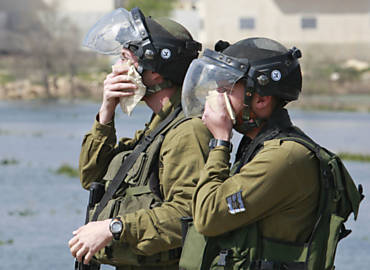 Soldados israelenses se protegem de gs lacrimogneo durante protesto na Cisjordnia