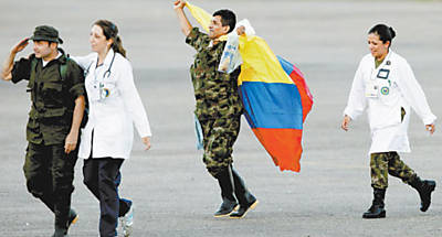 Acompanhado por mdicos, o sargento do Exrcito colombiano Luis Alfredo Moreno comemora a sua libertao pelas Farc agitando bandeira do pas