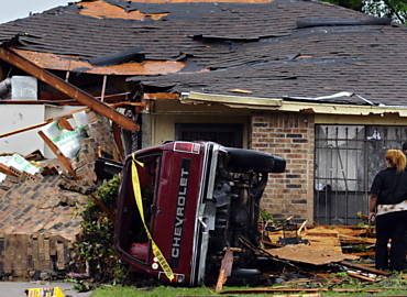 Pessoas observam estragos causados por tornado na cidade de Lancaster, ao sul de Dallas