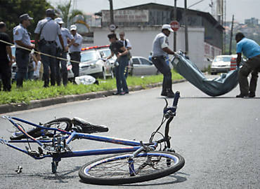 Bicicleta do ciclista Lauro de Jesus Neri, aps acidente; ao fundo, corpo  recolhido
