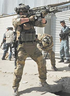 Militar aponta arma para prdio onde esto insurgentes, em Cabul