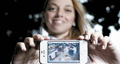 A chef de cozinha Nicoli Geigner mostra no celular imagens de cmeras de vigilncia de seu restaurante, em So Paulo