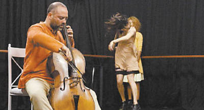 Dimos Goudaroulis toca violoncelo em meio a danarinos durante ensaio de 'Logos-Dilogos