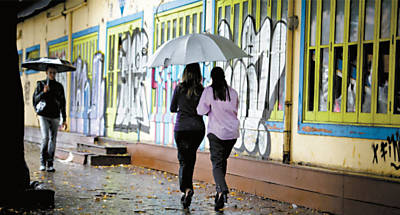 Pedestres utilizam guarda-chuvas para se proteger na avenida Faria Lima; previso  de mais frio para os prximos dias