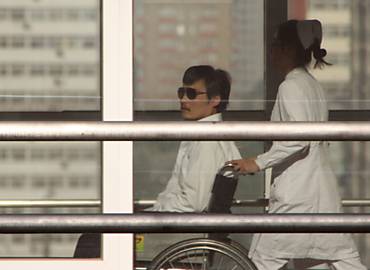 Na cadeira de rodas, Chen Guangcheng  empurrado por uma enfermeira no hospital Chaoyang, aps deixar embaixada