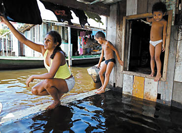 Maira Alves de Lima, 35, e os filhos, na casa de palafita invadida pelas guas do rio Negro