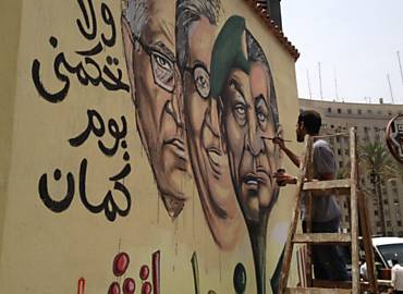 Omar "Picasso" pinta, na praa Tahrir, epicentro dos protestos no Cairo, grafite de candidatos  Presidncia do Egito