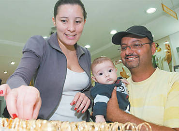 A dona de casa Tatiana com o marido, Renato, e o filho, Gabriel, de 5 meses, na loja em que comprou um novo par de alianas