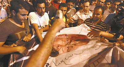 Manifestantes golpeiam com sapatos cartaz de Ahmed Shafiq, ex-premi de Mubarak, que disputar o 2 turno no Egito