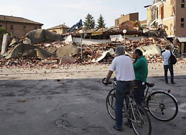 Moradores de Cavezzo, perto de Modena, diante de um dos prdios destrudos por tremor