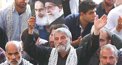 Imagem divulgada pelo governo mostra homem com fotografia dos aiatols Ali Khamenei ( dir.) e Ruhollah Khomeini