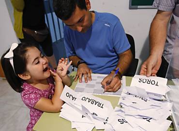 Garota observa a contagem de votos do referendo realizado em Guijo de Galisteo (Espanha)