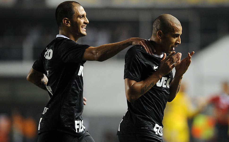Os conrinthianos Emerson e Fabio Santos comemoram o gol contra o Santos na partida pela Libertadores, na Vila Belmiro, em Santos Leia mais