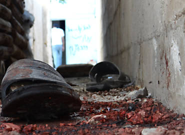 Um par de sandlias permanece em piso ensanguentado em Talbisah, rea prxima de Homs, onde houve tiroteio