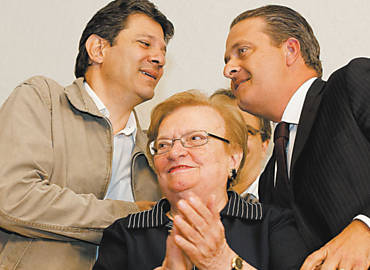 Erundina em ato no qual foi anunciada vice na chapa de Haddad, que, ao fundo, cumprimenta Eduardo Campos (PSB-PE)