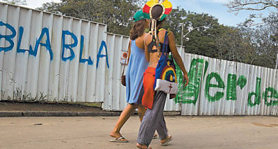 Participantes da Cpula dos Povos passam por muro pichado no aterro do Flamengo, na zona sul carioca, onde foram espalhadas dezenas de tendas por 26 mil metros quadrados