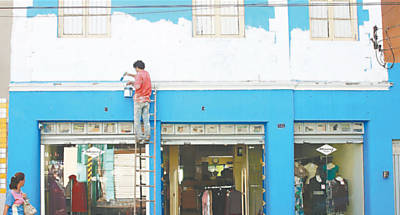 Fachada de loja na rua Visconde de Inhama, no centro de Ribeiro Preto, sendo pintada por causa da lei Cidade Limpa