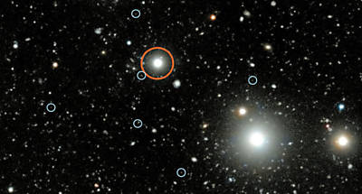 Imagem do Very Large Telescope modificada digitalmente mostra quasar (vermelho) e galxias escuras (crculos menores)