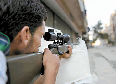 Rebelde aponta arma para tropas do ditador Bashar Assad durante conflito em Aleppo, a cidade mais populosa da Sria