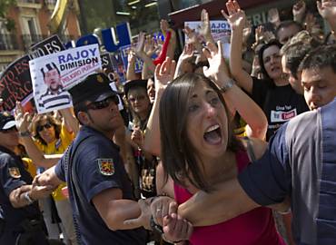 Em Madri, servidores pedem a sada do premi Mariano Rajoy diante da sede do seu partido, o PP; o PIB espanhol, como previsto, recuou 0,4% no 2 trimestre