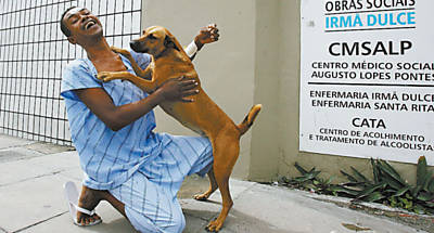 A cadela Nina brinca com seu dono, Renato Mrio dos Santos, em centro contra alcoolismo