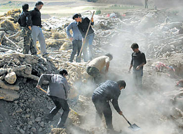 Homens vasculham as runas de uma vila atingida pelo terremoto perto da cidade de Varzaqan, no noroeste do Ir; tremores de anteontem deixaram mais de 300 pessoas mortas