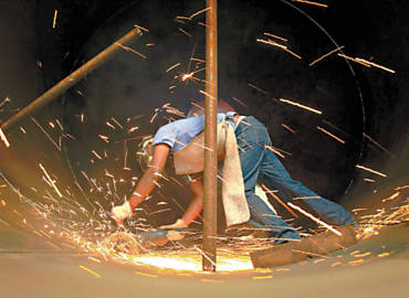 Trabalhador no setor de montagem e solda de componentes para caldeiras na fbrica Sermatec, em Sertozinho