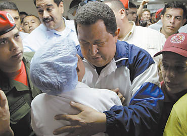 O presidente Hugo Chvez abraa uma venezuelana durante sua visita ontem a uma refinaria de petrleo que explodiu