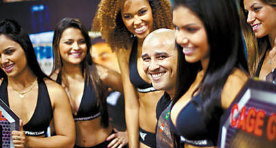 O promotor de lutas Antnio Tolentino, 35,  cercado por &#145;ring girls&#146; em uma feira do setor;  direita, lutadores se enfrentam em ringue em clube do Rio de Janeiro