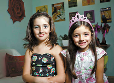 Las, 8 ( esq.), e Clara, 6, em sua casa em So Paulo; meninas pegam maquiagem da me