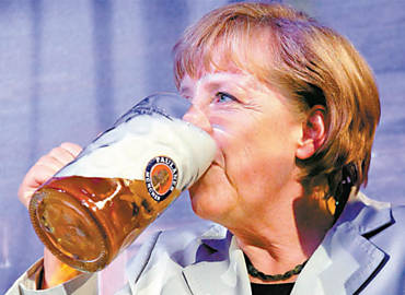 A chanceler Angela Merkel bebe cerveja durante evento da Oktoberfest alem, em Berlim