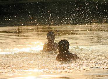 Garotos brincam em lagoa de afloramento do aqufero Guarani, no Jardim Interlagos, em Ribeiro; dia marcou 40,5C