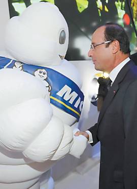 O presidente Hollande sada o mascote da Michelin, no Salo do Automvel de Paris