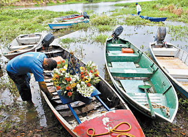 Pescador prepara canoa para procisso fluvial em homenagem a Nossa Senhora
