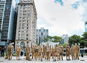 Grupo de atores vestidos como "executivos de pedra" faz performance na av. Paulista, centro financeiro de So Paulo