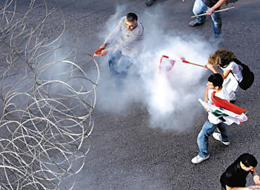 Indignao: Manifestantes tentam se proteger de gs lacrimogneo lanado pela polcia perto de sede do governo, que tentaram invadir