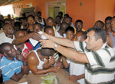 Representante do governo do Acre em Basileia, Damio Borges (dir.), entrega formulrios a haitianos que cruzaram fronteira