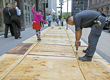 Funcionrio de manuteno refora com madeira calada em Manhattan por conta de furaco Sandy; NY est em alerta