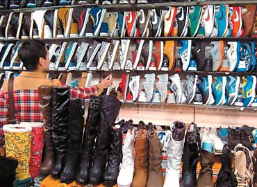 Mulher olha sapatos em Pequim; produto chins paga sobretaxa para entrar no Brasil