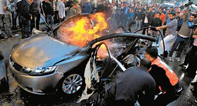 Palestinos tentam extinguir o fogo no carro que transportava o lder do Hamas Ahmed Jabari, alvo de um ataque areo